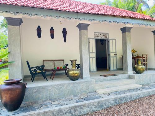 a house with a porch with vases on it at Birdsong Villa in Rathgama