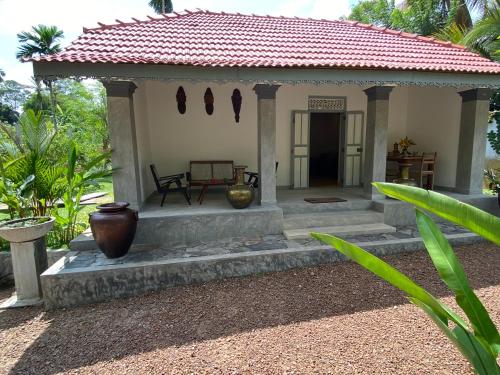 a small house with a red roof at Birdsong Villa in Rathgama