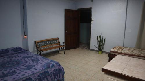 a bedroom with a bed and a bench and a table at Blue Morpho House B&B in Manuel Antonio