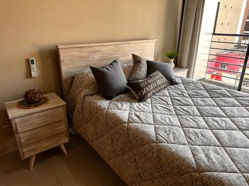 Un dormitorio con una cama grande con almohadas. en Aires del Sur en San Miguel de Tucumán