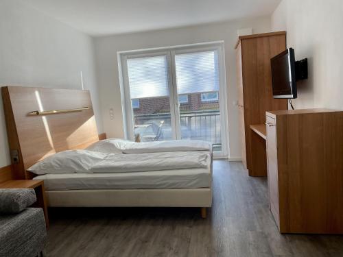 a bedroom with a bed and a large window at Stilvoll Wohnen in Oldenburg Kreyenbrück Apartments in Oldenburg