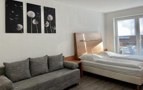 a living room with a couch and a bed at Stilvoll Wohnen in Oldenburg Kreyenbrück Apartments in Oldenburg