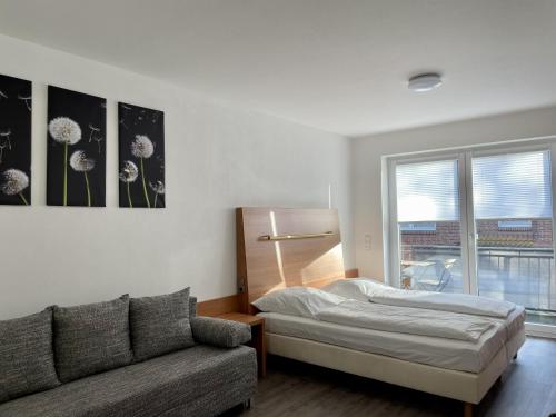 a living room with a bed and a couch at Stilvoll Wohnen in Oldenburg Kreyenbrück Apartments in Oldenburg