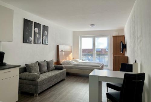 a living room with a couch and a bed at Stilvoll Wohnen in Oldenburg Kreyenbrück Apartments in Oldenburg