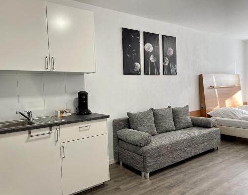 a living room with a couch and a kitchen at Stilvoll Wohnen in Oldenburg Kreyenbrück Apartments in Oldenburg