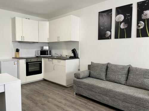 a living room with a couch and a kitchen at Stilvoll Wohnen in Oldenburg Kreyenbrück Apartments in Oldenburg