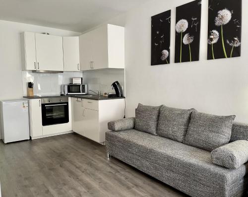 a living room with a couch and a kitchen at Stilvoll Wohnen in Oldenburg Kreyenbrück Apartments in Oldenburg