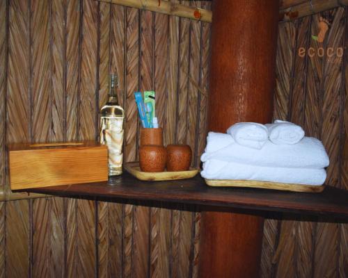 a wooden shelf with towels and a bottle of wine at Ecoco Homestay Mekong in Ben Tre