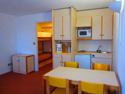 une petite cuisine avec une table et des chaises jaunes dans l'établissement Studio idéal famille avec piscine et balcon à Villard-de-Lans - FR-1-689-74, à Villard-de-Lans