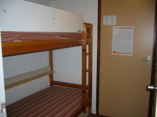 Cette chambre comprend 2 lits superposés et une porte. dans l'établissement Studio idéal famille avec piscine et balcon à Villard-de-Lans - FR-1-689-74, à Villard-de-Lans