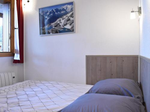 une chambre avec un lit et un tableau au mur dans l'établissement Appartement cosy, proche pistes et commerces, garage & balcon sud, 2 pièces, 4 personnes - Méribel - FR-1-180-378, à Les Allues