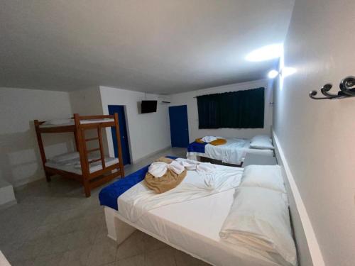 a hotel room with two beds and a chair at HOTEL BRISAS DE SANTA FE in Santa Fe de Antioquia