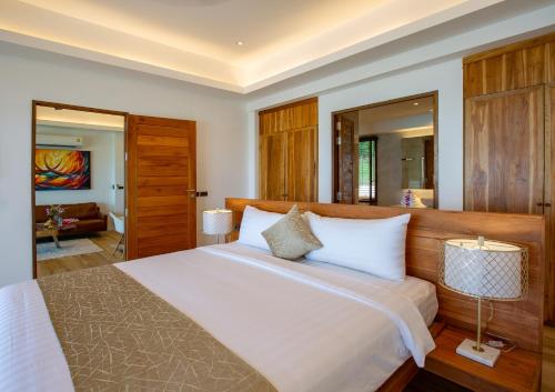 a bedroom with a large bed and a living room at Coconut Grove Resort in Ko Yao Yai