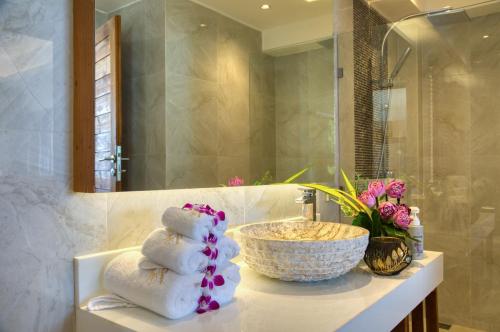 a bathroom with a sink and a counter with towels at Coconut Grove Resort in Ko Yao Yai