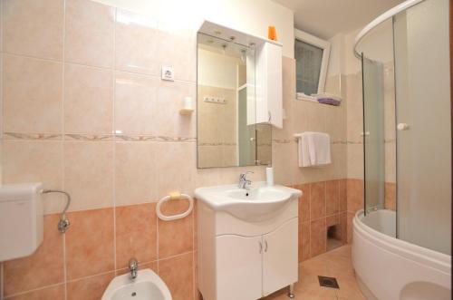 een badkamer met een wastafel, een toilet en een bad bij Apartment Gianfranko in Opatija