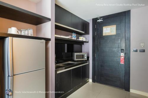 a kitchen with a refrigerator and a microwave at ✪✪✪✪✪ Patong Beachfront Studio Rooftop Pool Skybar in Patong Beach