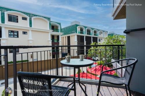 a balcony with a table and chairs on a balcony at ✪✪✪✪✪ Patong Beachfront Studio Rooftop Pool Skybar in Patong Beach