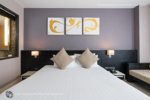 um quarto com uma grande cama branca com almofadas em ✪✪✪✪✪ Patong Beachfront Studio Rooftop Pool Skybar em Praia de Patong
