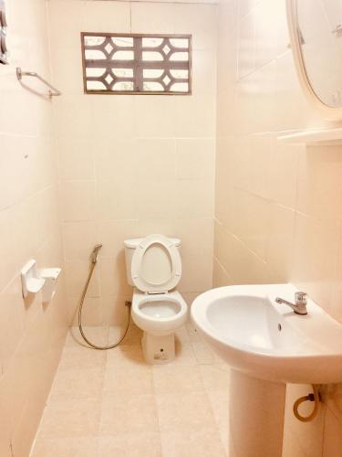 a white bathroom with a toilet and a sink at Lamai chalet in Amphoe Koh Samui