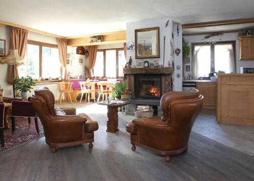 a living room with two chairs and a fireplace at Alpi & Golf Hotel in Bormio