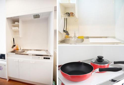 a white kitchen with a red pot on the stove at Ustay Kitakoiwa in Tokyo