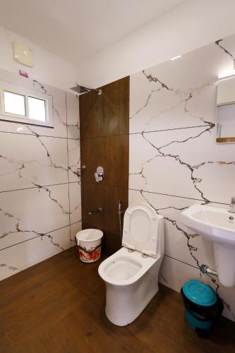 a bathroom with a toilet and a sink at BEN COTTAGE in Thekkady