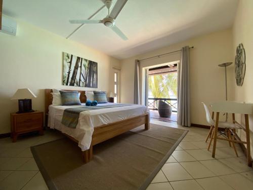 Un dormitorio con una cama con ventilador de techo. en Grand Baie Seaview Penthouse, en Grand Baie