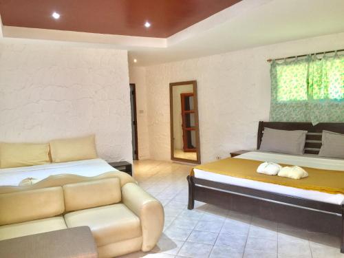 a bedroom with two beds and a couch in it at Lamai chalet in Amphoe Koh Samui