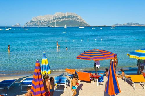 a group of people on a beach with umbrellas at Hotel Daniel in Murta Maria