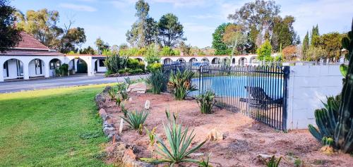 a fence with a pool in a yard at Azalea Motel in Coonabarabran