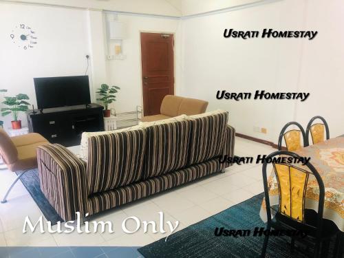 uma sala de estar com um sofá e uma televisão em Usrati Homestay by Amirul em Porto Dickson