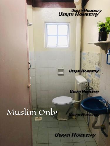 a bathroom with a toilet and a window at Usrati Homestay by Amirul in Port Dickson