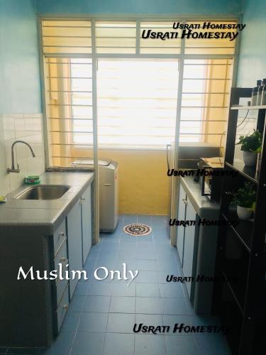 uma pequena cozinha com um lavatório e uma janela em Usrati Homestay by Amirul em Porto Dickson