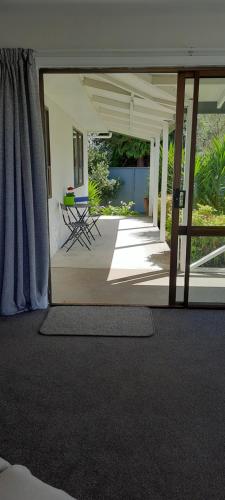 an open patio with a table and chairs in a house at Cosy on Courtney in Motueka