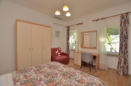 een slaapkamer met een bed, een bureau en een stoel bij Apartment Gianfranko in Opatija