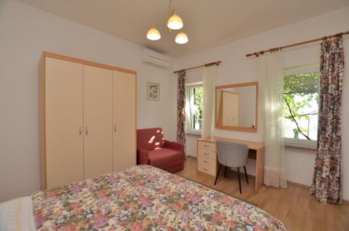a bedroom with a bed and a desk and a chair at Apartment Gianfranko in Opatija