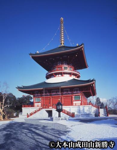 a large red building with a black roof at Narita U-City Hotel in Narita