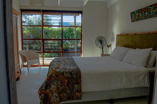 a bedroom with a bed and a large window at The Cowshed in McGregor