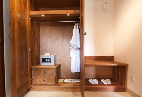 a bathroom with a wooden closet with a clock in it at Anumana Village Ubud in Ubud