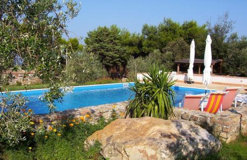 een zwembad met twee parasols in een tuin bij Villa Belvedere in San Vincenzo