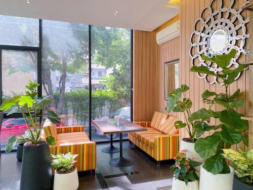 a room with a table and chairs and plants at Brighton Hotel in Bangkok