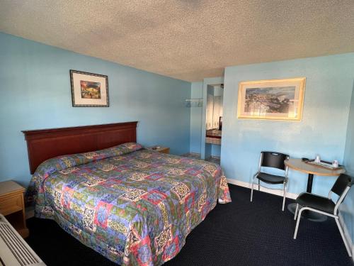 une chambre d'hôtel avec un lit, une table et des chaises dans l'établissement Deluxe Inn LA, à Los Angeles