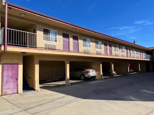 ein Gebäude mit einem Auto auf einem Parkplatz in der Unterkunft Deluxe Inn LA in Los Angeles