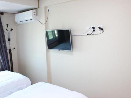 a room with a refrigerator with a mirror and a bed at The Lucete Hotel in Seogwipo