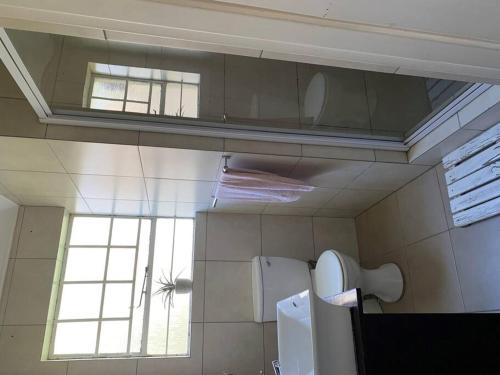baño con lavabo, espejo y ventana en Cheerful 3-bedroom home indoor & outdoor fireplace, en Johannesburgo