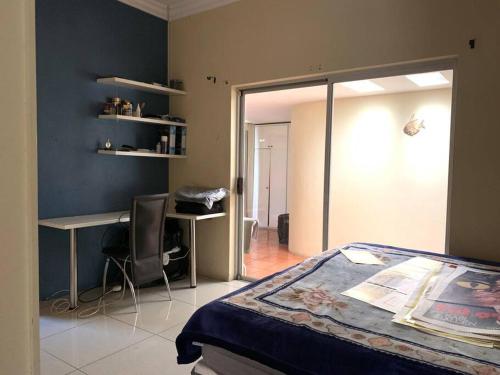 1 dormitorio con cama, escritorio y silla en Cheerful 3-bedroom home indoor & outdoor fireplace, en Johannesburgo