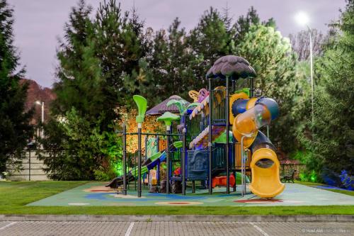 a playground in a park with a colorful playground at Hotel Aldi in Gura Humorului