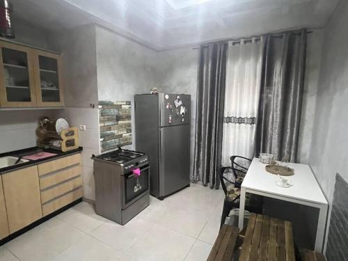 a kitchen with a refrigerator and a table in it at Very nice apartment with view of all the old city in Jerusalem
