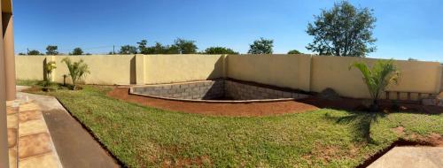 a backyard with a retaining wall and a fence at Ranzi Court in Palatswe