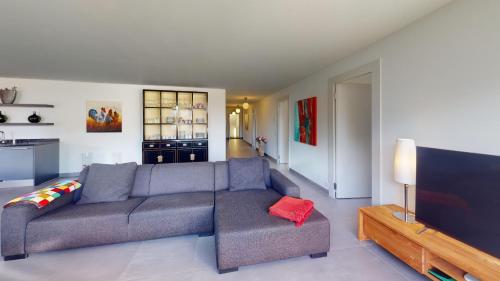 a living room with a couch and a flat screen tv at Family Apartment Sot Lantsch-Lenzerheide for 6 persons in Lenz
